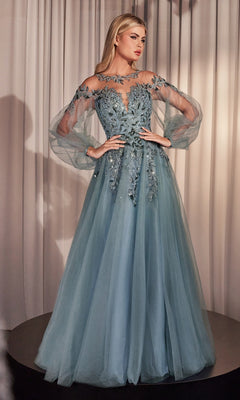 A woman wearing the Sheer Long Sleeve Long Formal Dress A1263, a floor-length blue gown with sheer sleeves and intricate floral embroidery, stands before light-colored curtains.