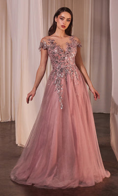 A woman in the Andrea and Leo A1350 Dusty Rose Prom Ball Gown with an off-the-shoulder, floor-length design and floral sequin bodice stands before sheer curtains.