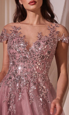 A woman wears the Andrea and Leo A1350 Dusty Rose Prom Ball Gown, featuring silver sequin floral embroidery and a sheer neckline.