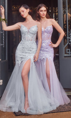 Two women pose elegantly in front of glass doors wearing Andrea & Leo A1388 strapless mermaid prom dresses with sheer bodices, sequins, high slits, and tulle skirts, radiating formal glamour.