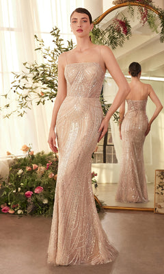 A woman in the Andrea and Leo A1411 long beaded formal dress with a lace-up back stands before a mirror, surrounded by greenery and flowers in a softly lit room.