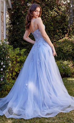 Outdoors, a woman wears the Embroidered Long Prom Dress: Andrea & Leo A1417—a light blue, floor-length gown with an embroidered bodice, floral embellishments, and thin straps—as she looks over her shoulder.