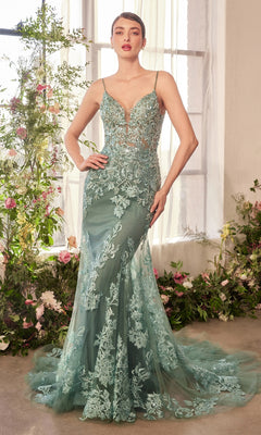A woman poses indoors among flowers, wearing the Andrea & Leo A1421 Beaded-Lace Long Prom Dress—a fitted, floor-length teal gown with floral lace accents, sheer panels, and thin straps, her hand resting on her hip.