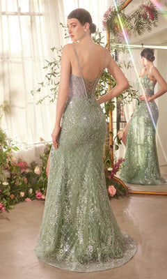 A woman in the Andrea & Leo A1470 pale green long beaded corset prom dress with a low back and spaghetti straps stands before a mirror in a flower-adorned room.