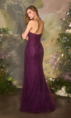 A woman in the Andrea and Leo A1497 long prom dress stands with her back turned, surrounded by lush greenery and floral decorations.