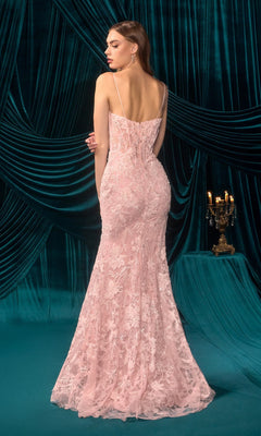 A woman in the Andrea and Leo A1499 long pink lace prom dress with thin straps stands facing away, set against teal velvet drapes and a lit candelabrum.