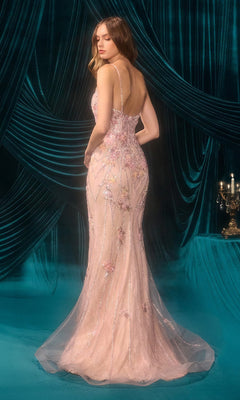 A woman wears the Andrea and Leo A1500, a fitted light pink floral beaded lace prom dress with thin straps, standing on teal carpet before teal draped curtains and a candelabra.