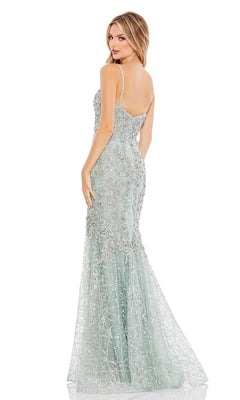 A woman poses with her back to the camera in the Mint Green Glitter Prom Gown, Mac Duggal A20242—a floor-length mermaid dress sparkling with embellishments.