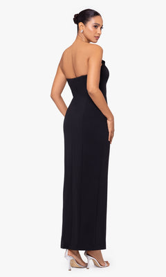 A woman faces away in the Strapless Long Black Tuxedo Prom Dress A24228 with clear heels, exuding chic style against a white background.