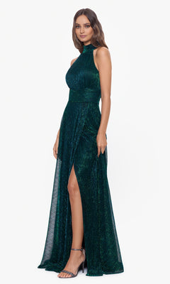 Woman wearing the Empire-Waist High-Neck Long Shimmer Prom Dress A24948 in emerald green, featuring a sleeveless design, thigh-high slit, and metallic shimmer, paired with high-heeled sandals.