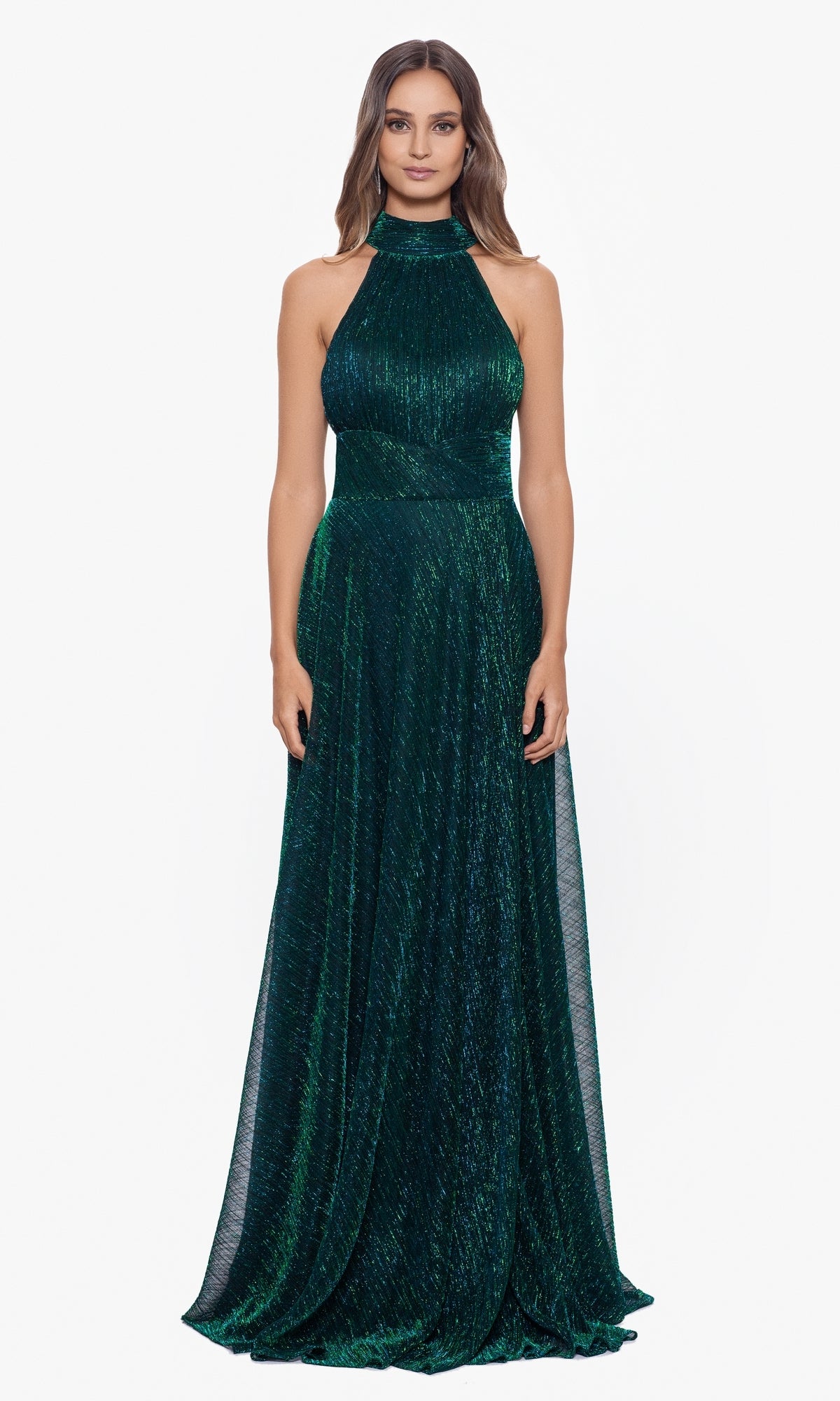 A woman faces forward, wearing the Empire-Waist High-Neck Long Shimmer Prom Dress A24948, a sleeveless, floor-length gown in dark green with textured, shimmering fabric.