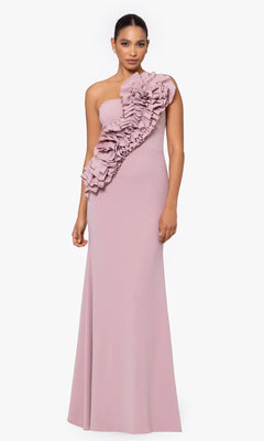 A woman models the Betsy and Adam One-Shoulder Long Prom Dress A26071 in mauve, featuring a floor-length silhouette and bold front ruffle detailing, standing against a plain white background.