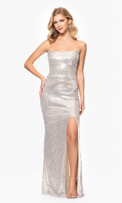 A woman in the Betsy & Adam A26952 long champagne prom dress stands against a plain white background.