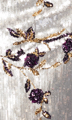 Close-up of silver sequin fabric with purple and gold floral embroidery, ideal for creating the Long Formal Dress: Betsy and Adam A26994, a stunning form-fitting or strapless gown featuring elegant roses and leaves.