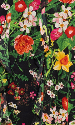 Close-up of fabric from the Betsy & Adam A27102 Floral Wedding Guest Dress, showcasing a vibrant floral print with red, yellow, pink, and white flowers on a black background.