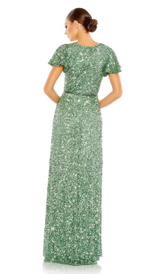 A woman with her hair in a neat bun faces away, wearing the floor-length green Mac Duggal 5540 Short-Sleeve Sequin Formal Dress.