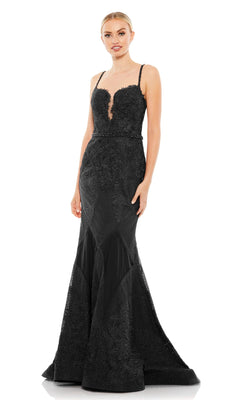 A woman models the Mac Duggal A79082, a fitted, floor-length black prom dress featuring embroidery, lace accents, thin straps, a sweetheart neckline, and a beaded waistline.