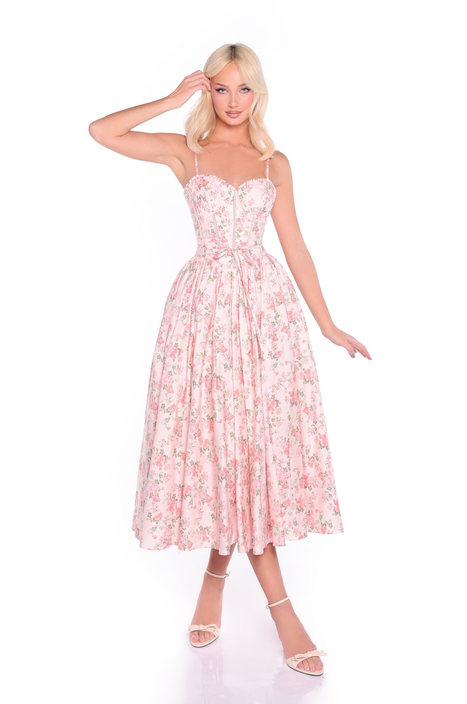 Woman wearing the Midi Fit-and-Flare Pink Floral Summer Dress: Aloura, a light pink, sleeveless, midi-length dress with a fitted bodice and full skirt, posing against a plain white background.