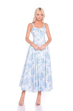 A woman models the Anselma Blue Floral Cotton Summer Midi Dress, featuring a fitted bodice and flared skirt—an ideal fit-and-flare choice for summer events—posed against a plain white background.