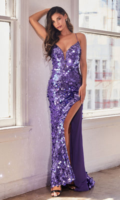 A woman stands indoors by large windows, wearing the Unique Corset-Back Long Sequin Prom Dress B1141—sleeveless with a deep V-neckline, purple sequins, and a thigh-high slit.