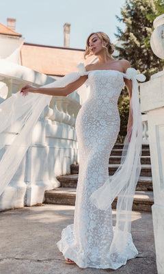 A woman poses outdoors on stone steps beside a white balustrade, wearing the Tina Holly BB010 Strapless White Wedding Gown.