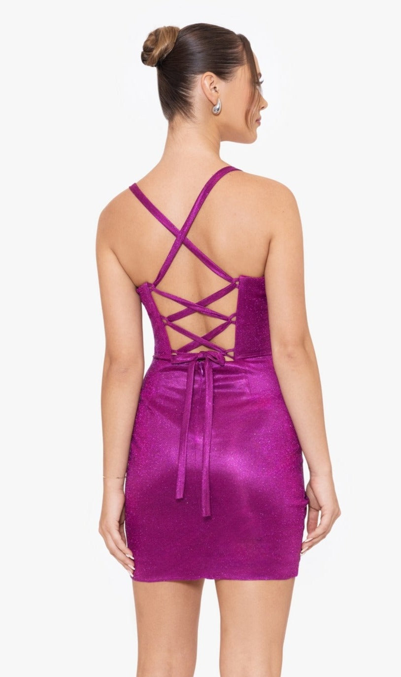 A woman faces away, wearing the sparkly Short Party Dress BC117 by Blondie Nites. The sleeveless fuchsia mini dress features a sweetheart neckline, crisscross lace-up back detailing, and a bow accent at the waist.