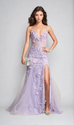 A woman in the Chicas C328 floral-embroidered long prom dress, featuring lavender sheer fabric and a thigh-high slit, holds a silver clutch against a plain light background.
