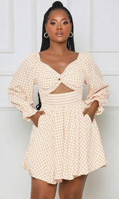 A woman stands against a plain light background wearing the Long-Sleeve Short Casual Gingham Print Dress in apricot, featuring an a-line silhouette, long sleeves, front cut-out, pockets, and a light gingham print.