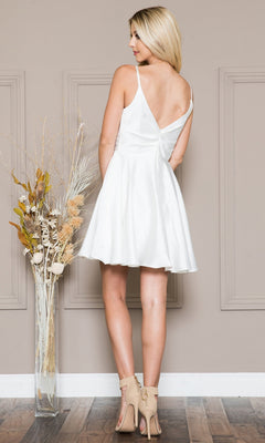 A woman in the Short Holiday Party Dress with Pockets BZ013S—a chic, sleeveless white satin A-line with V-back—stands facing away before a taupe wall and tall dried plants, showcasing this stylish dress perfect for any occasion.