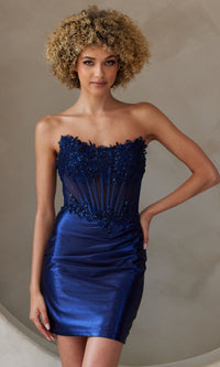 Woman wearing a navy blue strapless short dress standing in front of a neutral background