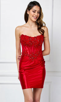 Woman wearing a short red strapless dress with bead embellishments on the corset bodice against a white background