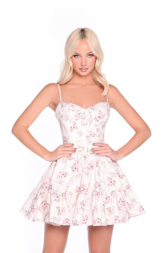 A blonde woman stands with her hands on her hips, wearing the Cream Rose Print Corset Sundress: Brielle.