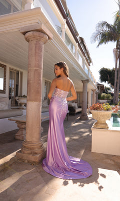 A woman wearing the Strapless Sweetheart Long Prom Dress C1346 with a sheer corset bodice stands outdoors near a column, with a pool, palm tree, and large house in the background.