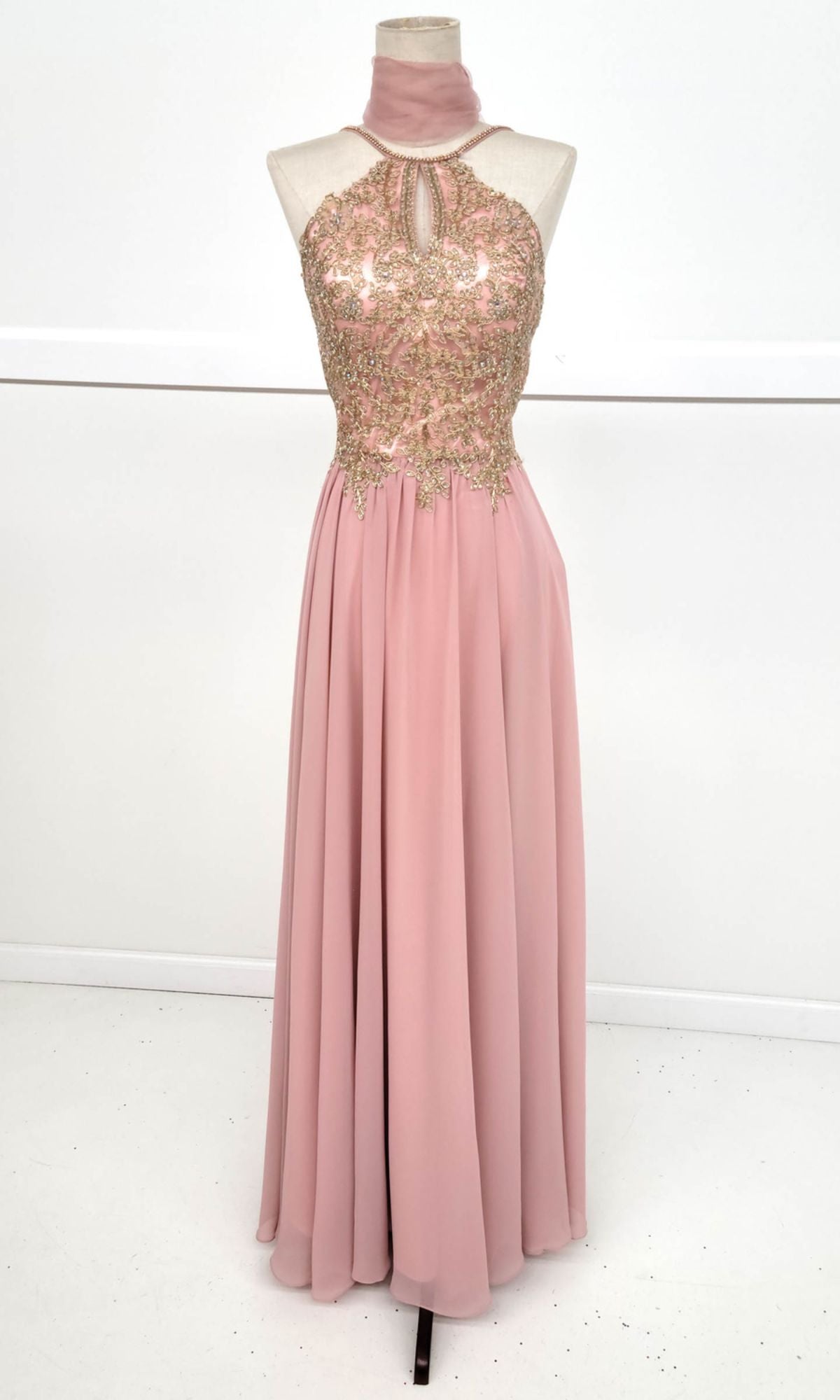 Chicas C1521 High-Neck Long A-Line Prom Dress: Sleeveless blush pink gown with golden lace-embroidered bodice, keyhole neckline, high-neck collar, and flowing chiffon skirt displayed on a dress form.