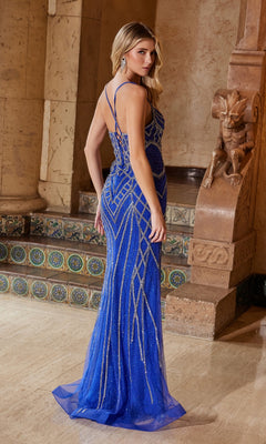 A woman wears the Nox Anabel C1607 Embellished Long Prom Dress, featuring a fitted royal blue design with spaghetti straps, as she stands indoors on marble flooring near an ornate stone structure and tiled steps.
