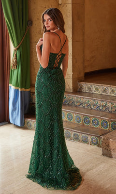A woman stands indoors by tiled stairs and a green curtain, wearing the Nox Anabel C1616: a floor-length, dark green V-neck long beaded prom dress with a lace-up back, looking over her shoulder.