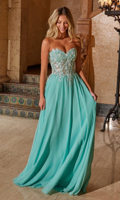 A woman stands indoors wearing the Nox Anabel C1617 Strapless Sweetheart Prom Dress in sage green, featuring a sheer embroidered bodice and a flowing, floor-length skirt.