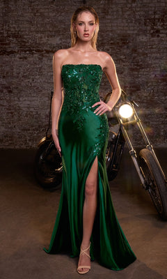 Woman in an emerald green strapless dress with sequins and a high slit, standing in front of a motorcycle.