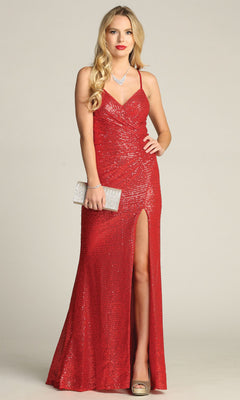 Woman poses against a plain background in the Chicas C2402 Lace-Up Long Sequin Prom Dress with thigh-high slit and open back, styled with a silver clutch, gold heels, and jewelry.