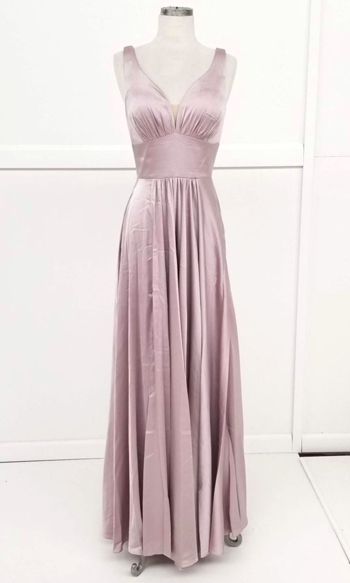 The Chicas C242 Empire-Waist Long A-Line Prom Dress features a sleeveless, floor-length light mauve satin design with a fitted bodice, V-neckline, and wide waistband, shown on a mannequin against a white background.