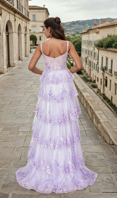 Wearing the Tiered Long Ruffle Prom Dress: Chicas C2433, a woman stands on a stone walkway amid historic buildings and lush greenery.