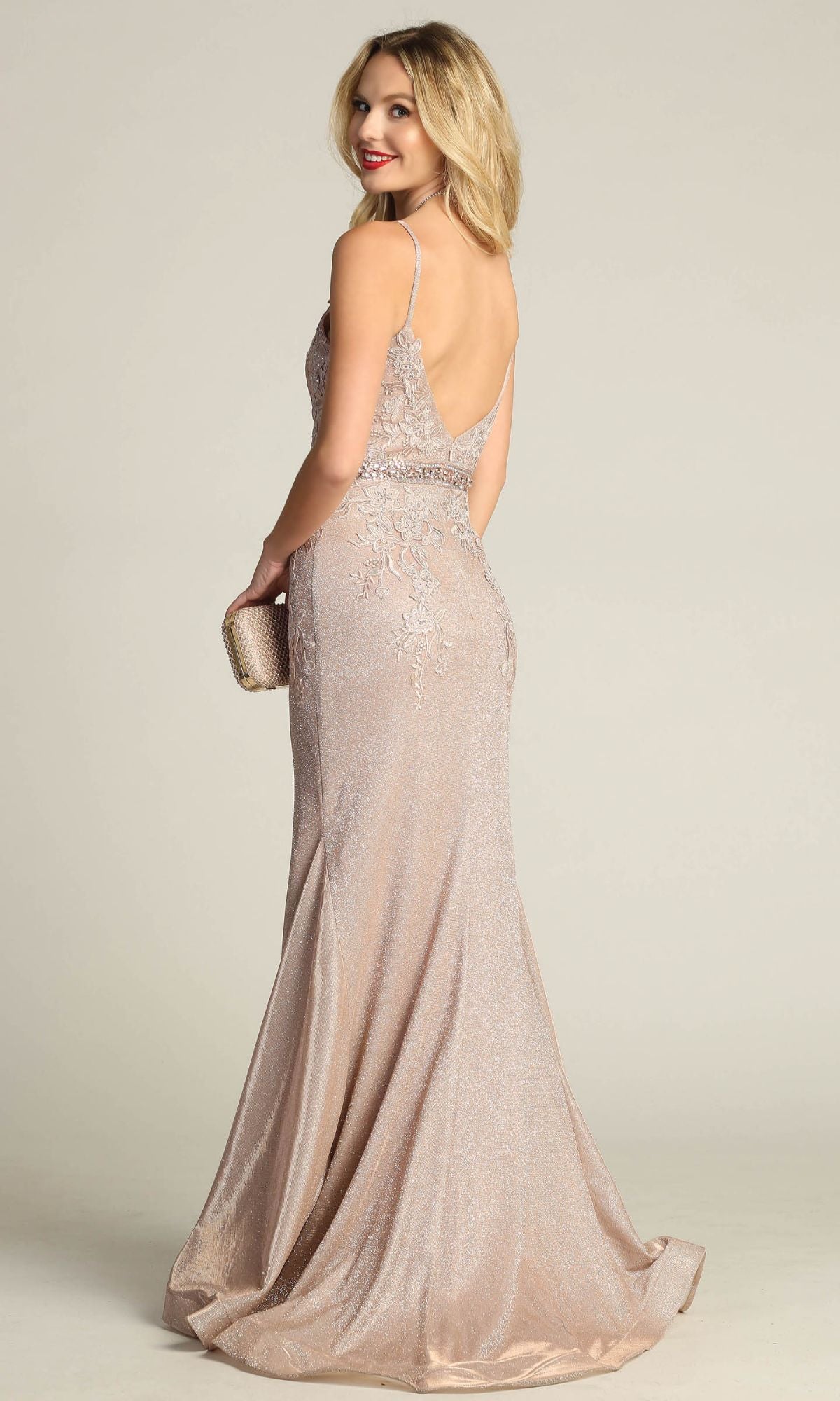 A woman in the Chicas C243 Low-Back Long Mermaid Prom Dress poses against a plain background, showcasing its floor-length silhouette, thin straps, and elegant low-back design while holding a clutch.