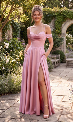 A woman stands on a stone path in a garden, wearing the Chicas C2575 long prom dress in Rose. The elegant, off-the-shoulder satin gown features convenient pockets, a dramatic thigh-high slit, and an A-line floor-length skirt that flows gracefully with every step.
