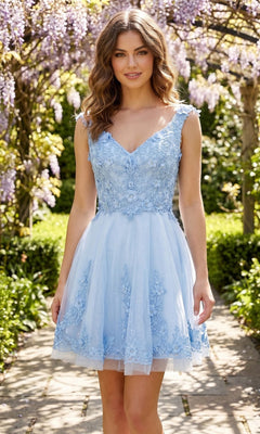 A woman stands outdoors wearing the Chicas C311 Short Homecoming Dress in baby blue, featuring delicate lace floral embellishments. Purple wisteria flowers and green foliage create a vibrant backdrop.