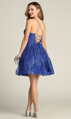 A woman wearing the Lace-Up Glitter-Print Short Homecoming Dress C317 stands facing away, holding a silver clutch and wearing silver high heels.