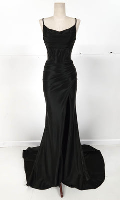 The Chicas C326 Cowl-Neck Long Prom Dress features black satin fabric, thin straps, a fitted bodice with ruched detailing, high slit, and slight train, shown on a dress form against a plain background.