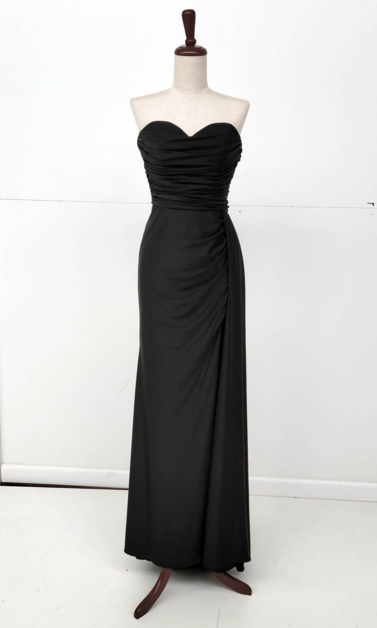 The Chicas C327 Side-Sash Strapless Long Prom Dress in black, with a sweetheart bodice and ruched details, is elegantly displayed on a dress form against a plain white background.