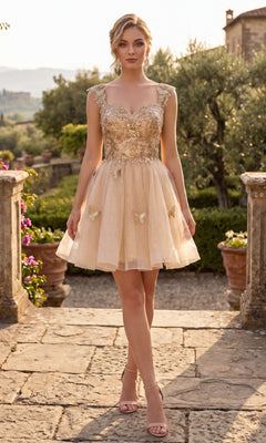 A woman stands outdoors in a stone courtyard, wearing the Chicas C330 short homecoming dress in champagne, featuring a sleeveless design with gold floral lace appliques and an elegant a-line tulle skirt, paired with nude heels.