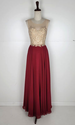 The Embroidered-Bodice Long Prom Dress: Chicas C3320 features a gold embroidered bodice, sheer neckline, and flowing burgundy A-line skirt, elegantly displayed on a dress form against a plain background.