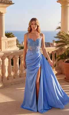 A woman stands on a sunny terrace in the Chicas C341 Long Prom Dress, a blue floor-length gown featuring a corset bodice, lace details, high slit, and thin straps. The sea and classical architecture are visible in the background.